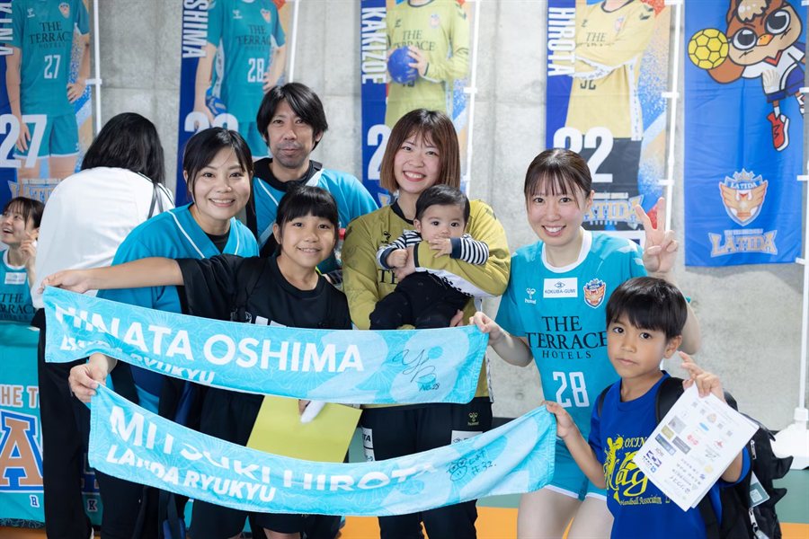 タオルを掲げて選手と記念撮影するファン